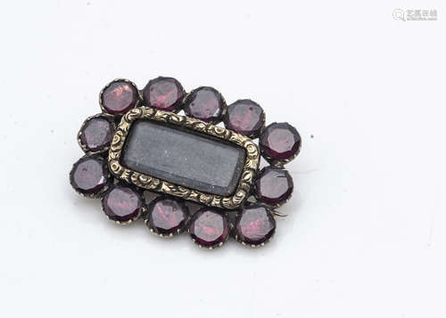 A Georgian garnet mourning brooch, the circular almandine garnets in collar settings centred