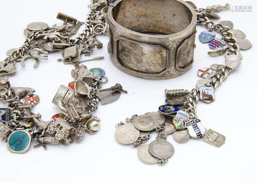 Three silver charm bracelets, with various charms and silver and enamel shield badges, together with