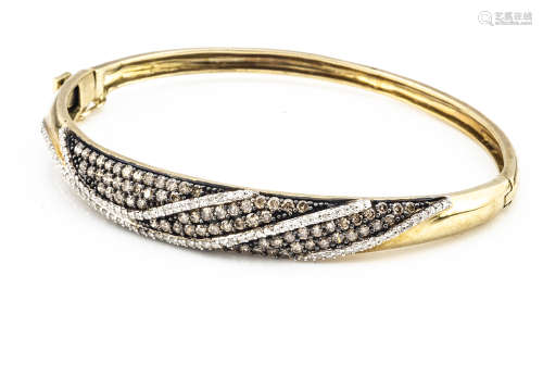A contemporary 9ct gold diamond hinged bangle, the colourless and coloured diamonds of brilliant cut