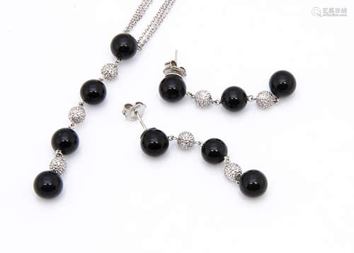 An 18ct white gold necklace and earring set, the three strand necklace supporting an onyx and