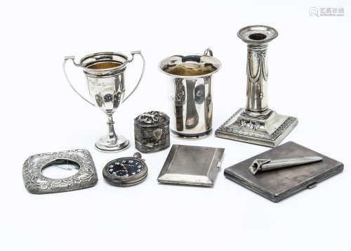 Two Art Deco period silver cigarette cases, together with a small silver trophy cup, a silver