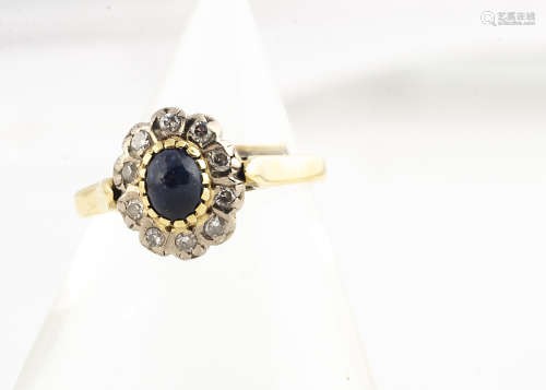 A continental sapphire and diamond cluster ring, all in yellow metal marked 750, with cabochon