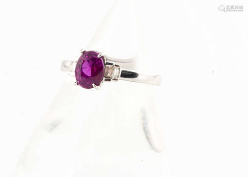 An 18ct gold pink sapphire and baguette cut diamond dress ring, the oval mixed cut claw set sapphire