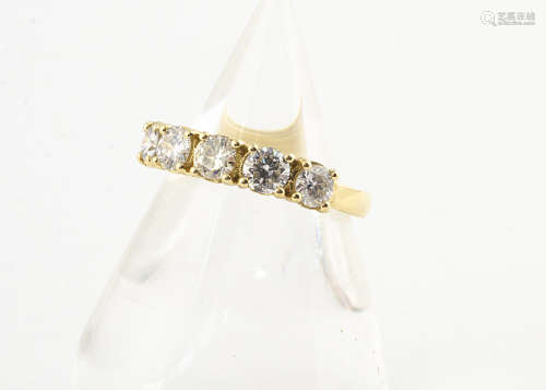 An 18ct gold diamond set five stone ring, the brilliant cuts in claw settings on a thick yellow gold