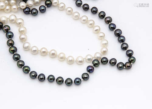 Two opera len*** uniform knotted strings of cultured pearls, one in black, 74cm, the other in cream,