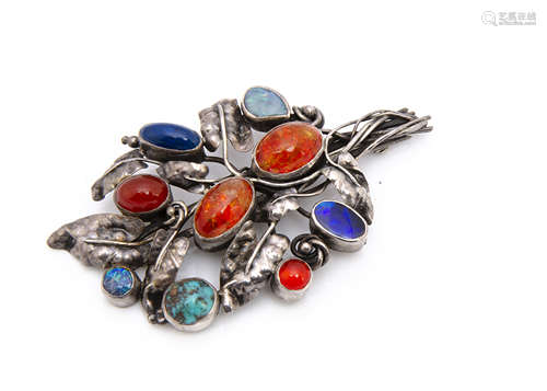 An Arts and Crafts silver and gem set floral brooch, set with two oval cabochons of Baltic amber,