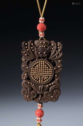 AN AGARWOOD CARVED GOLD INLAID PENDANT