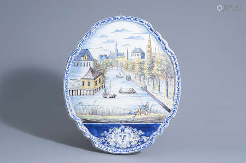 A large polychrome Dutch Delft plaque with a cityscape with a river, Makkum, 19th C.