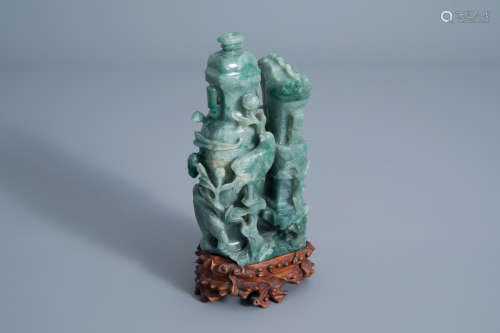 A Chinese green jade vase and cover with birds among blossoming branches on a wooden stand, 20th C.
