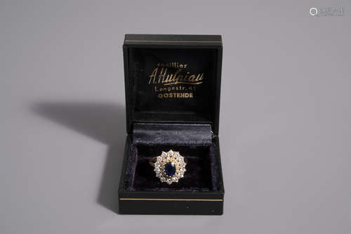 An 18 carat yellow gold ring set with a blue sapphire and 28 diamonds, 20th C.