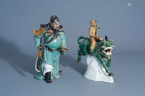 Two Chinese Shiwan pottery models of a warrior and a boy riding a Buddhist lion, 20th C.