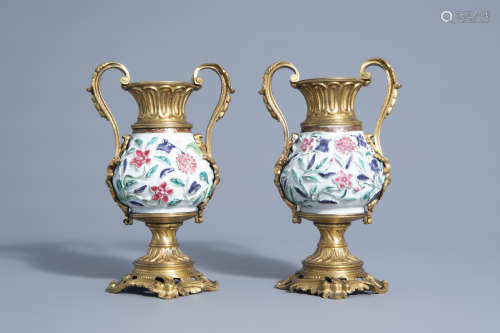 A pair of Chinese gilt bronze mounted famille rose vases with floral relief design, Yongzheng and 19