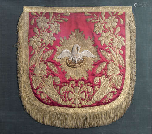 A framed fragment of a chasuble in silk and silver and gold thread with a pelican feeding the young,