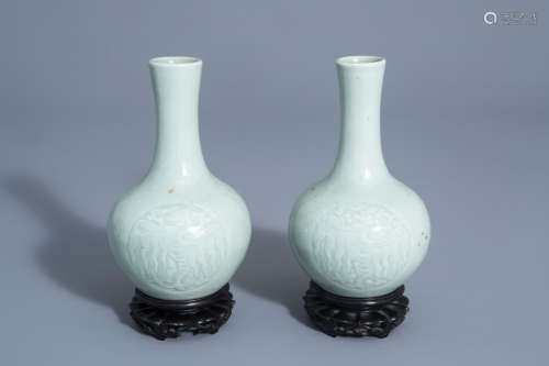 A pair of Chinese monochrome celadon bottle vases with incised phoenix medallions, Yongzheng mark, 1