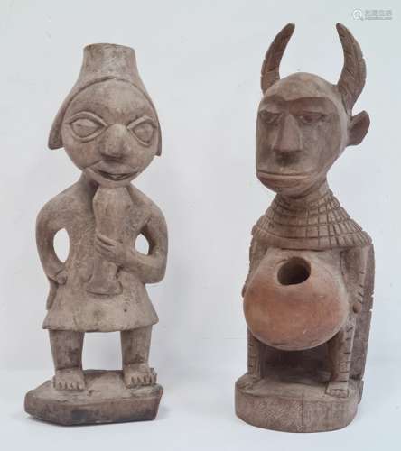 Carved African figure, possibly West African, horned with carved cloak and hole to stomach, 32cm
