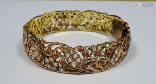 Indian(?) gold, ruby and seedpearl bangle, pierced scroll and floral decoration, unmarked, 42.5g
