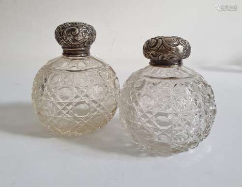 Pair of early 20th century silver lidded and glass circular cut glass scent bottles, the silver