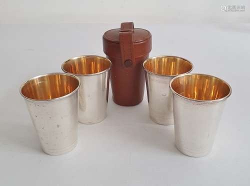 Set of four silver shooting / travelling / hunting cups with gilt wash interiors in a fitted brown