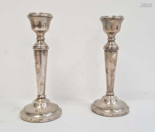 A pair of 20th Century silver mounted candlesticks, tapering on circular bases, 19cm high