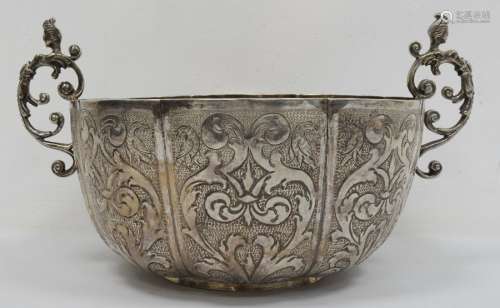 A silver coloured two-handled bowl, hammered and engraved decoration of birds and scrolls, female