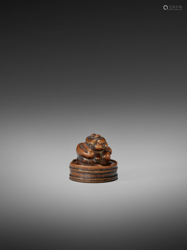 AN EARLY WOOD NETSUKE OF OKAME IN A BA…