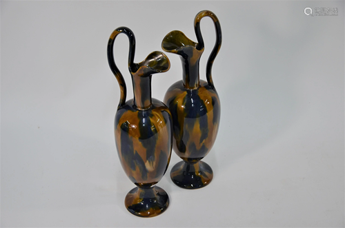 A pair of stoneware ewers of slender form