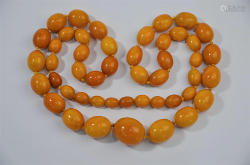 A graduated row of orange amber beads