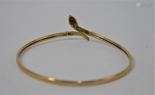 A yellow metal bangle in the form of a coiled serpent,