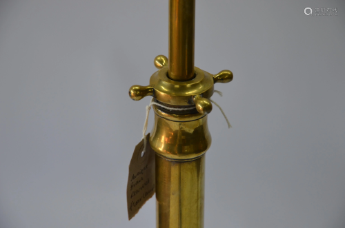 An antique brass standard lamp on a relief pr…