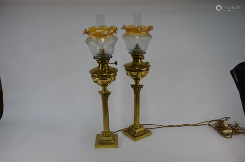 A companion/matched pair of brass column oil lamps