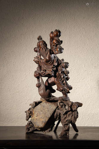 A Chinese Longan Wood Carved Scholar With Monkey