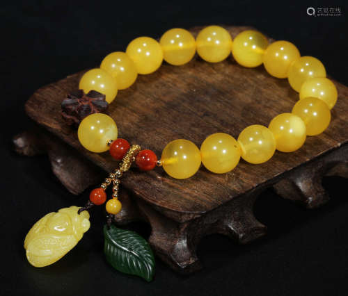 AN AMBER STRING BRACELET WITH 15 BEADS