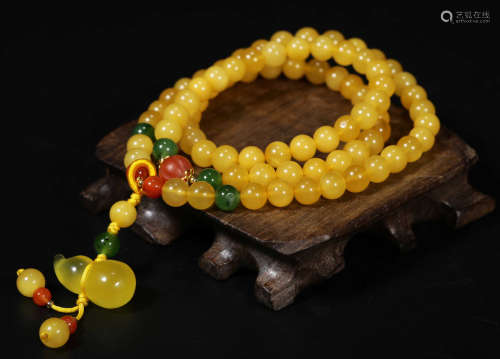 AN AMBER STRING BRACELET WITH 108 BEADS