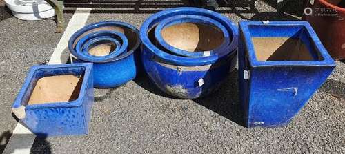 Seven royal blue glazed planters of square tapered and bulbous round forms, largest 51cm diameter (