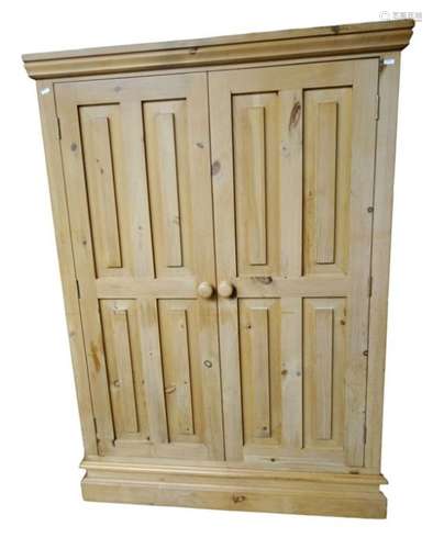 Pine two-door short wardrobe with panelled doors opening to reveal hanging space, raised on