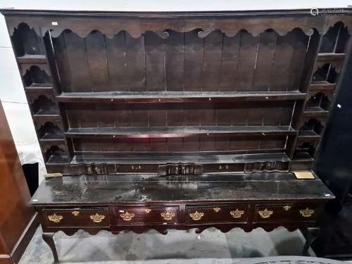 Possibly 18th century oak dresser with moulded cornice above various open shelves and short drawers,