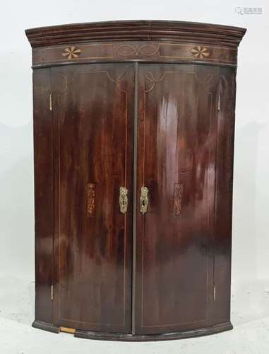 19th century mahogany bowfront wall-hanging corner cupboard, the ogee moulded pediment above two