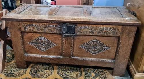 Oak coffer with carved channel decoration to the top, carved front and stile supports