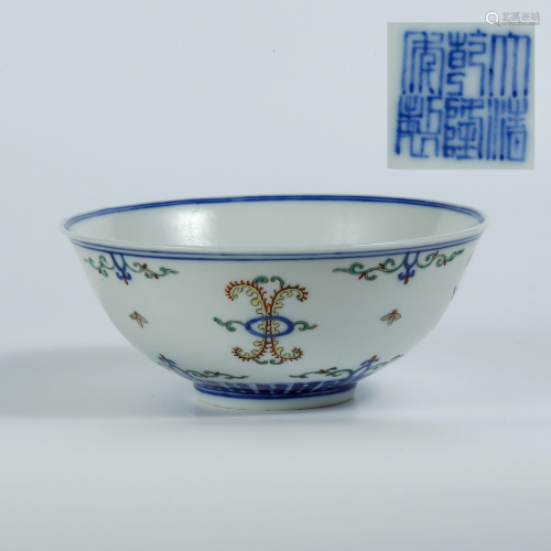 A blue and white bowl with bat and flower design in