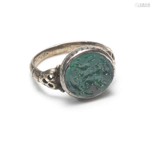 A green paste intaglio and silver ring, 19th century, or earlier