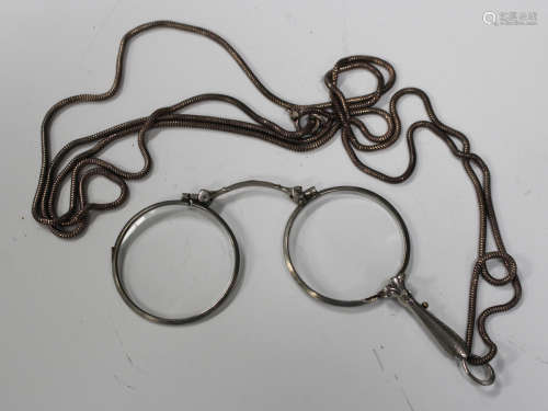 A pair of plated folding lorgnettes, fitted with circular lenses, with a Brazil link neckchain