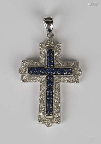 A 9ct white gold, sapphire and diamond pendant, designed as a cross, mounted with a row of