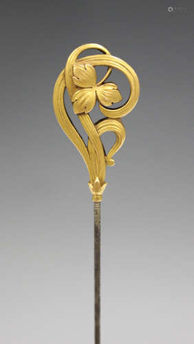 A French gold topped stickpin, circa 1910, in an Art Nouveau floral design, length of top 3.5cm.