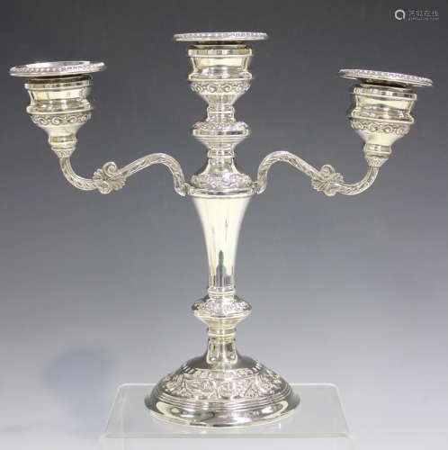 An Elizabeth II silver twin-branch candelabrum with detachable beaded nozzles, on a tapering
