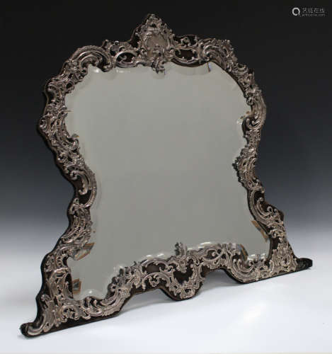 An Edwardian silver mounted dressing table mirror, the bevelled plate within a silver frame,