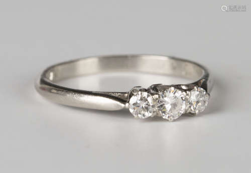 A platinum and diamond three stone ring, mounted with a row of circular cut diamonds, detailed '