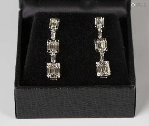 A pair of white gold and diamond pendant earrings in a graduated design, mounted with baguette and