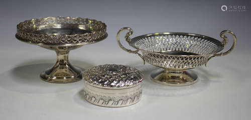 A late Victorian silver circular box and screw cover, the top decorated in relief with running