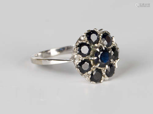 A white gold and sapphire eight stone cluster ring, claw set with the principal circular cut