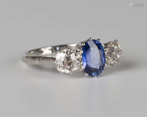 A platinum, sapphire and diamond ring, claw set with an oval cut sapphire between diamond single